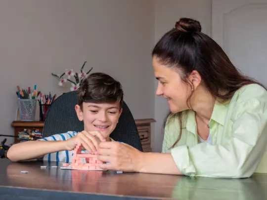 Caregiver and child working together during an ABA therapy activity