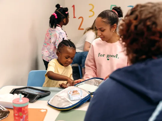 Child participates in an ABA therapy session with a Registered Behavior Technician (RBT) during a structured learning activity in a clinic setting.